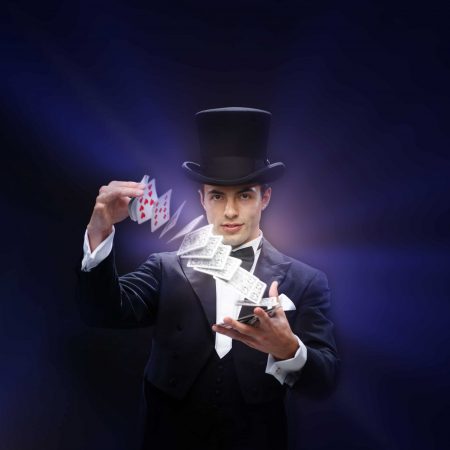 magician showing trick with playing cards magic, performance, circus, gambling, casino, poker, show concept - magician in top hat showing trick with playing cards